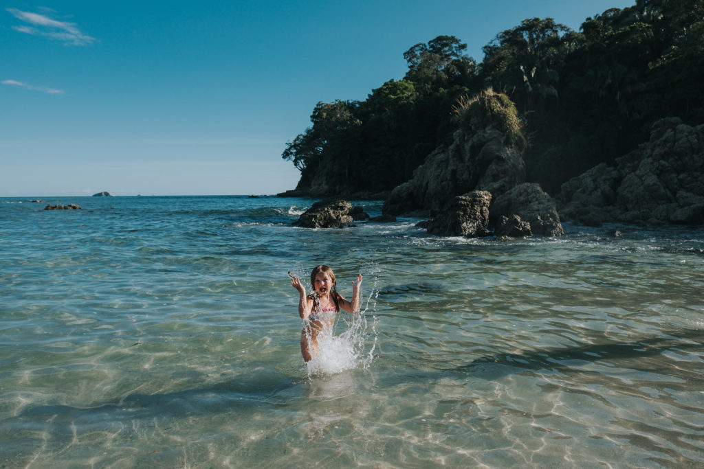 child splashing in waves on beach costa rica parque de manuel antonio