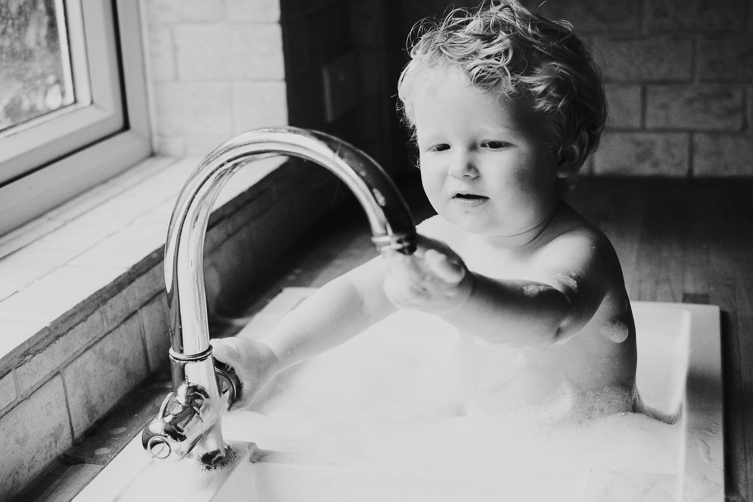 ashford baby photographer blonde baby boy and bubbles in kitchen sink bath