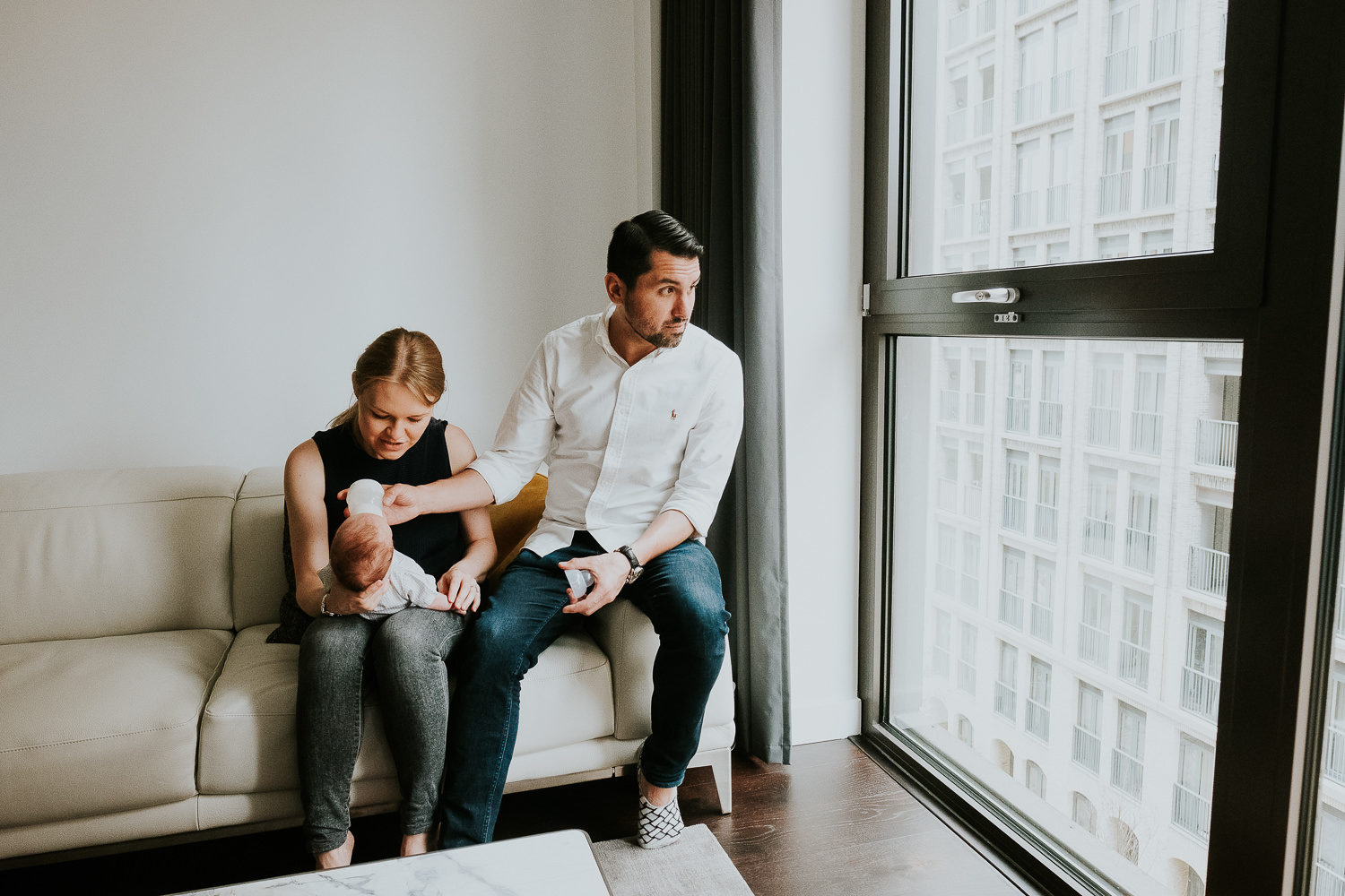 LONDON NEWBORN PHOTOS LIFESTYLE NATURAL LIGHT PORTRAIT OF BABY WITH PARENTS BOTTLE FEEDING
