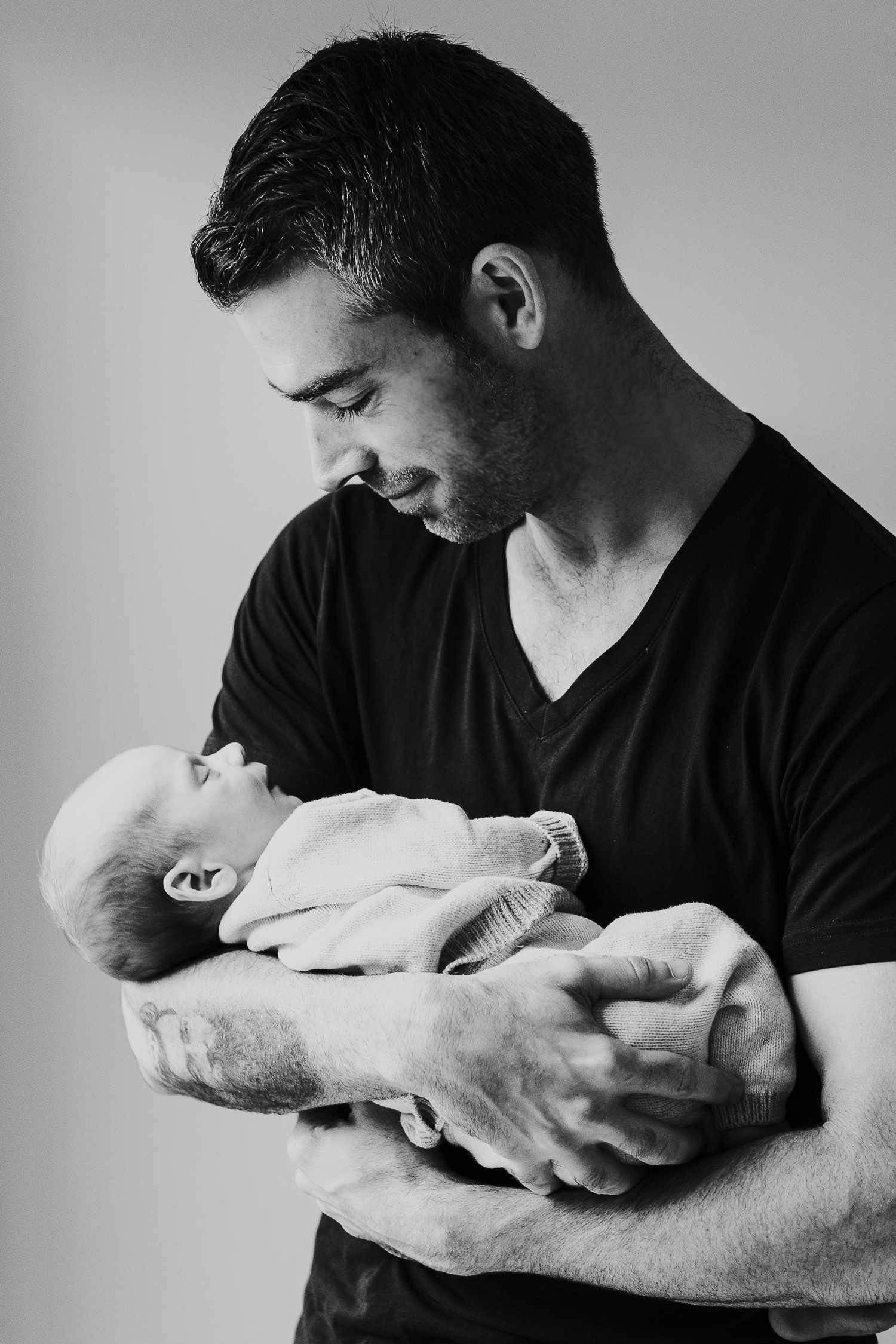 father holding baby son black and white photo london newborn photography