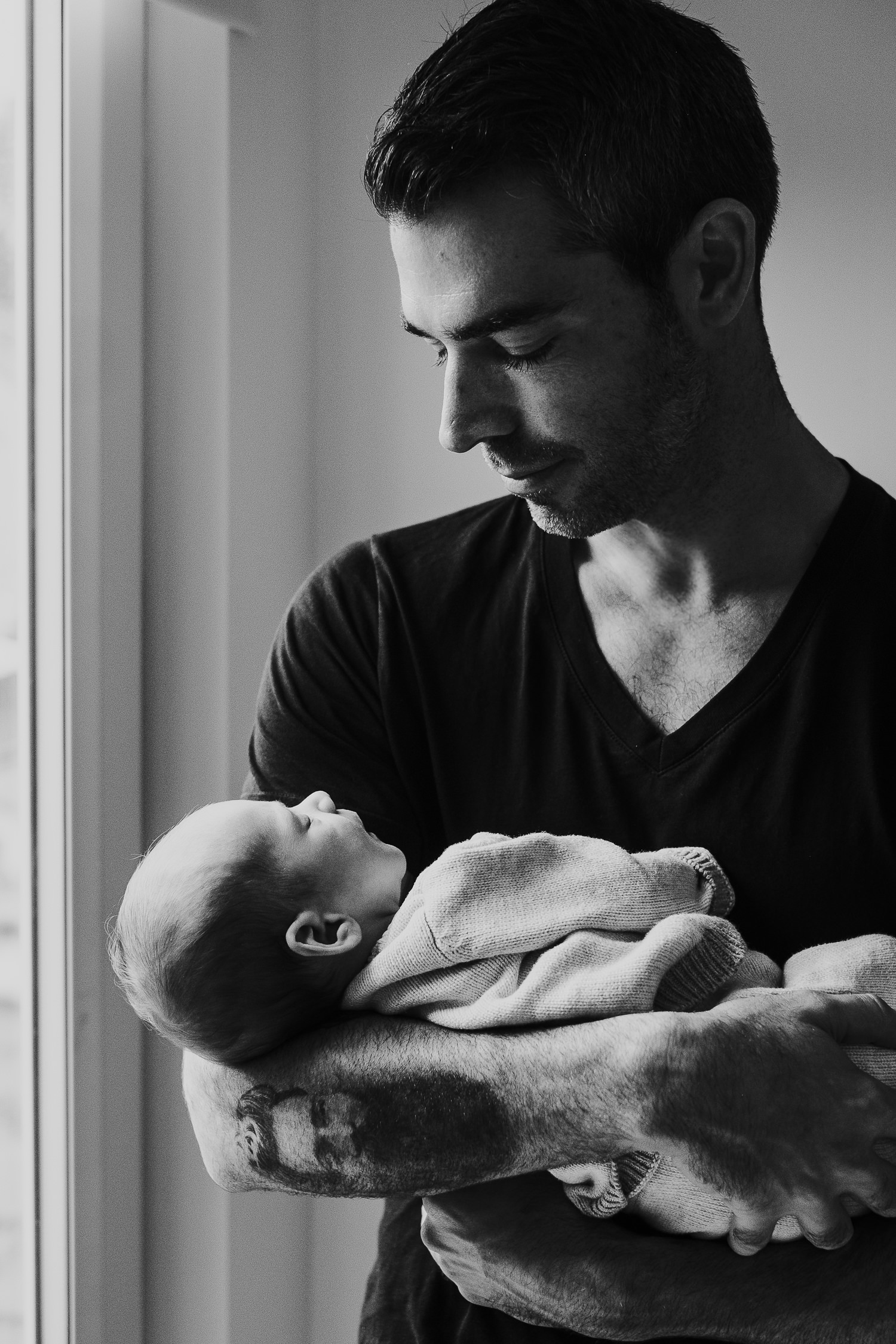 father holding baby son black and white photo london newborn photography