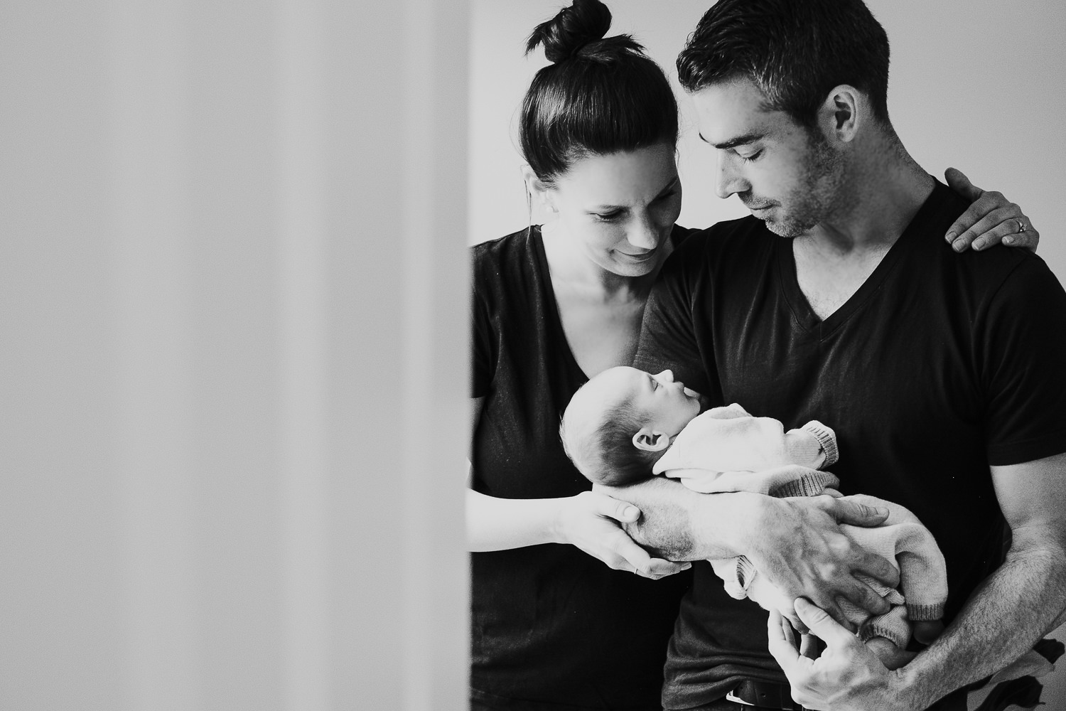 new parents holding baby son black and white photo london newborn photography