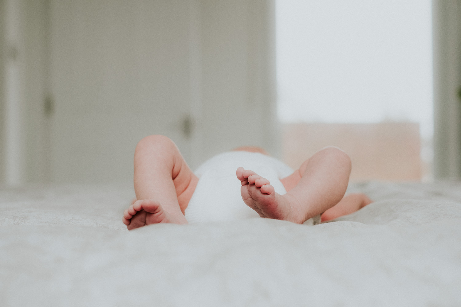 newborn baby feet close up lying on bed london newborn photography