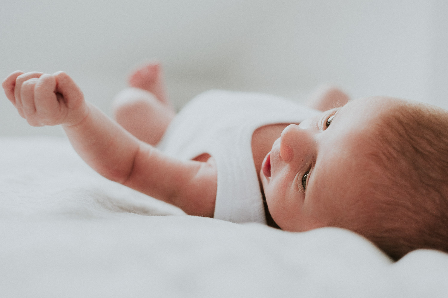 newborn baby boy lying on bed london newborn photography