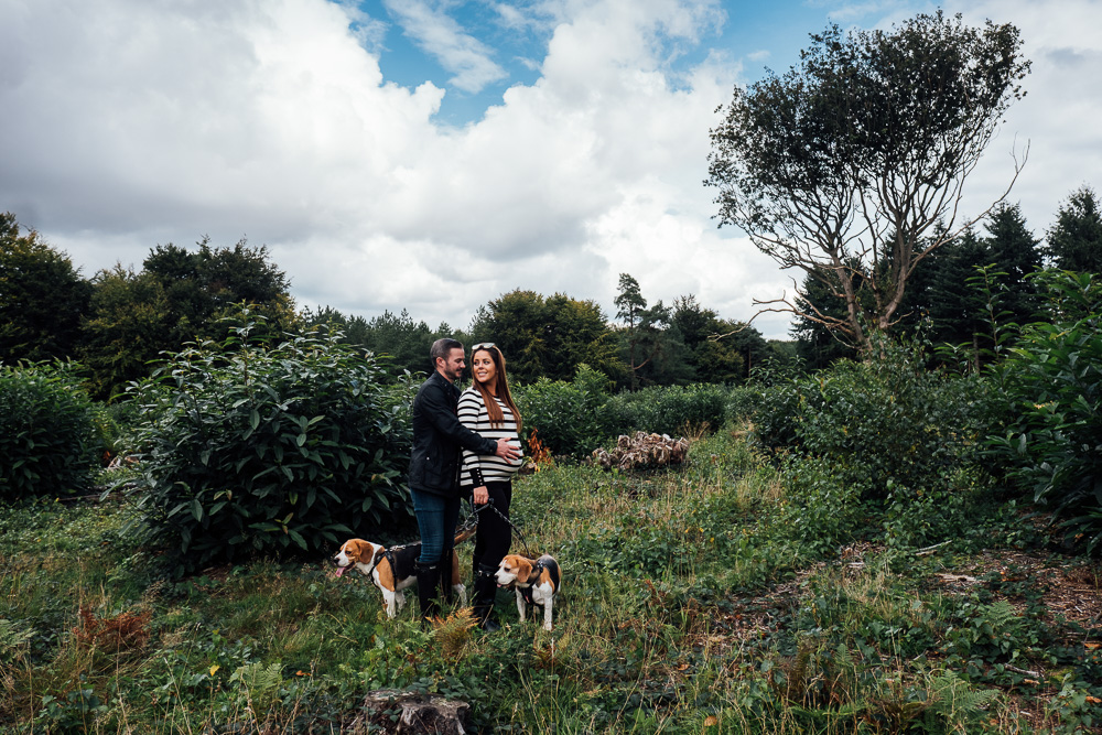 MATERNITY PHOTOGRAPHER LONDON AND KENT WOODLAND PHOTO OF COUPLE WITH DOGS