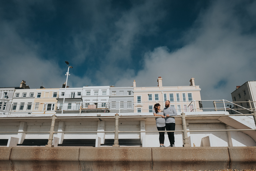 PREGNANT COUPLE ON BEACH PROMENADE HASTINGS MATERNITY PHOTOGRAPHER LONDON