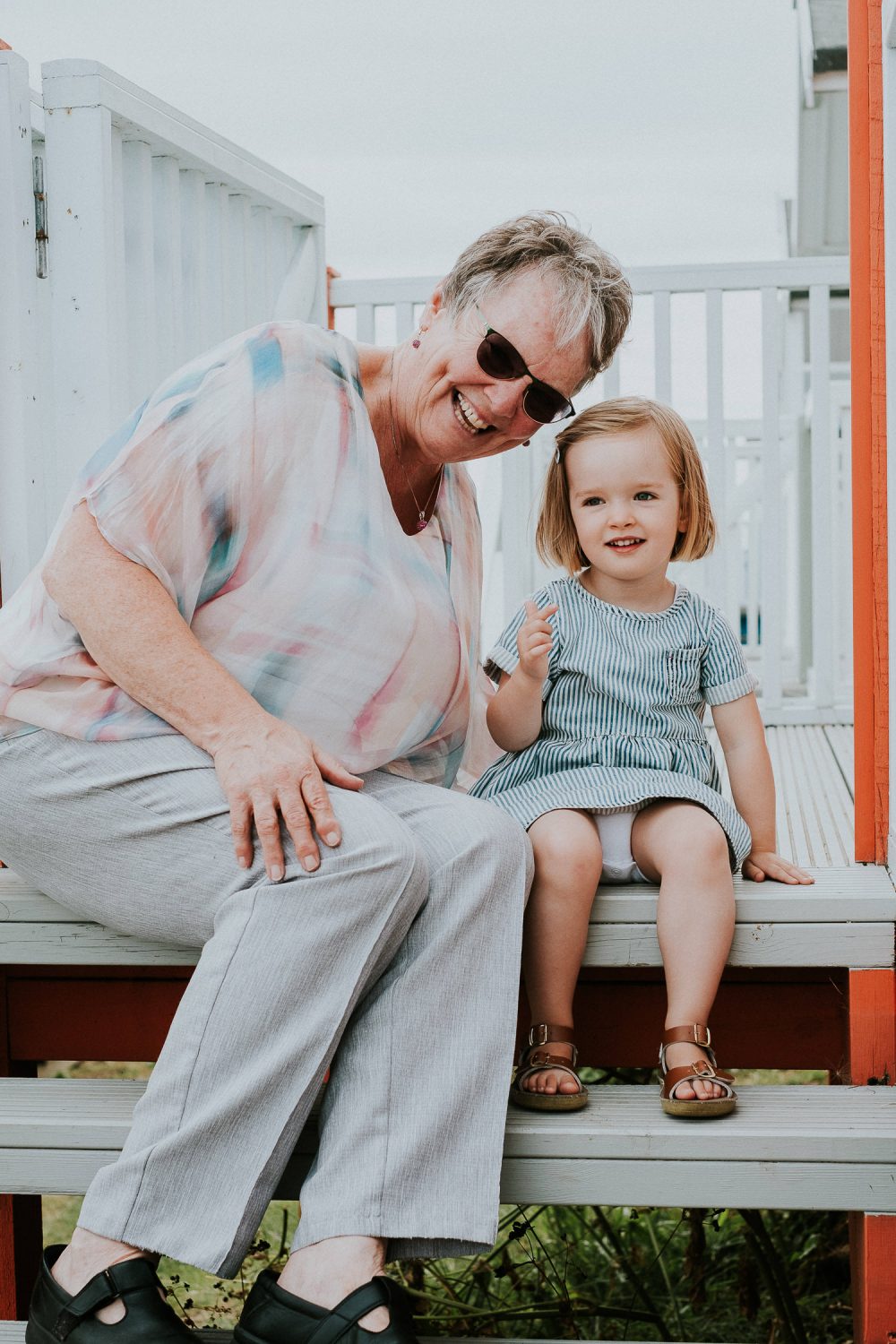 GIRL SITTING WITH GRANDMOTHER ON BEACH HUT STEPS IN WHISTABLE KENT