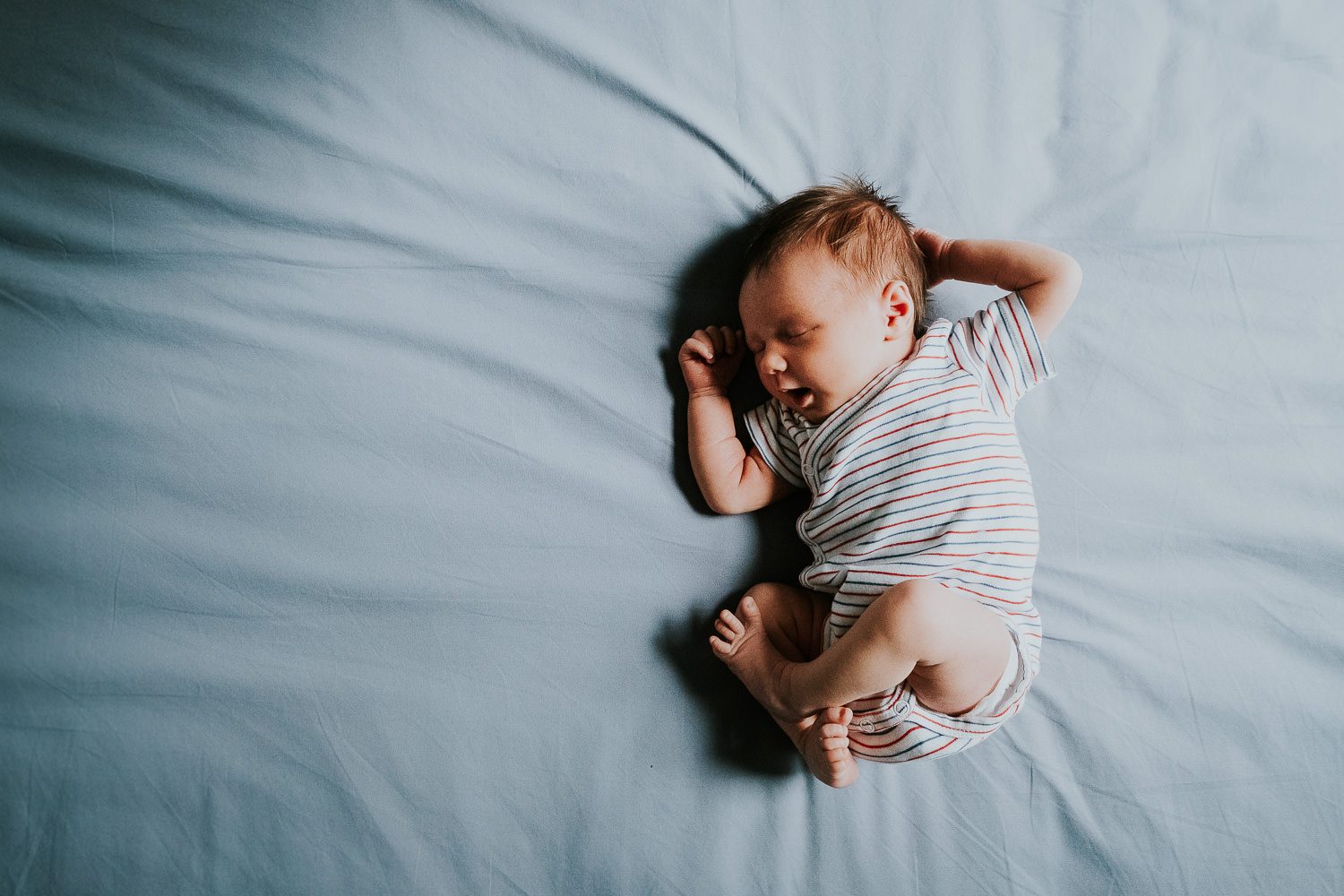 South Kensington Newborn Photographer. Baby girl in cot on side.