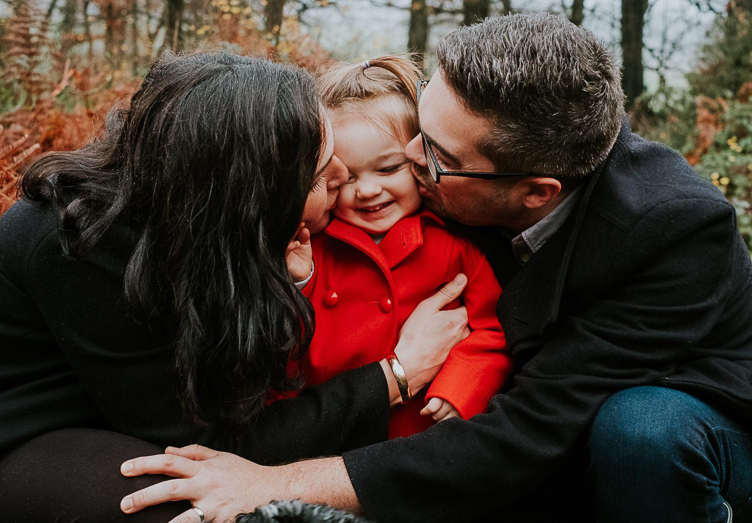 Surrey maternity photographer parents kissing toddler
