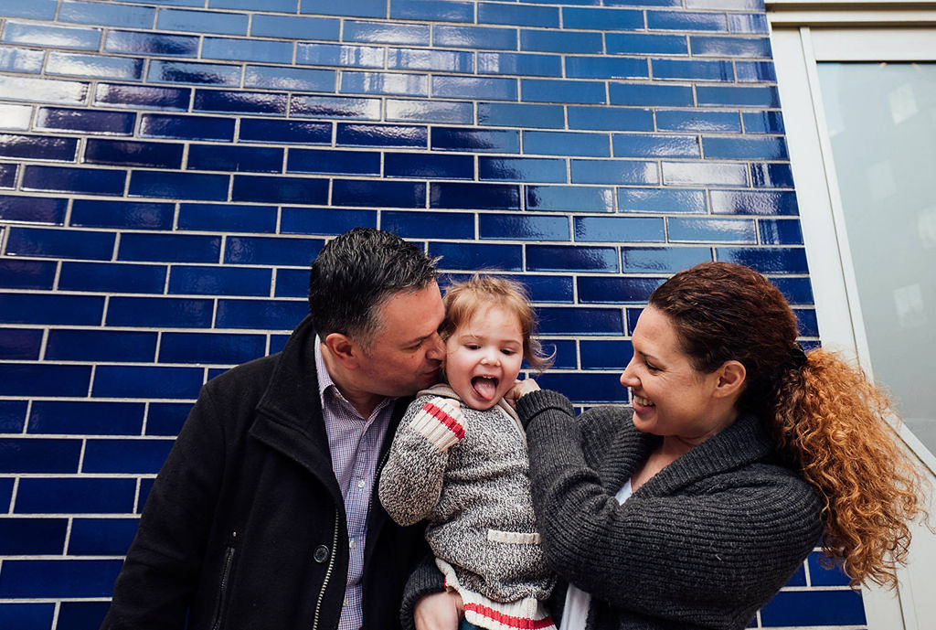 london family photographs parents with toddler in front of tiled wall