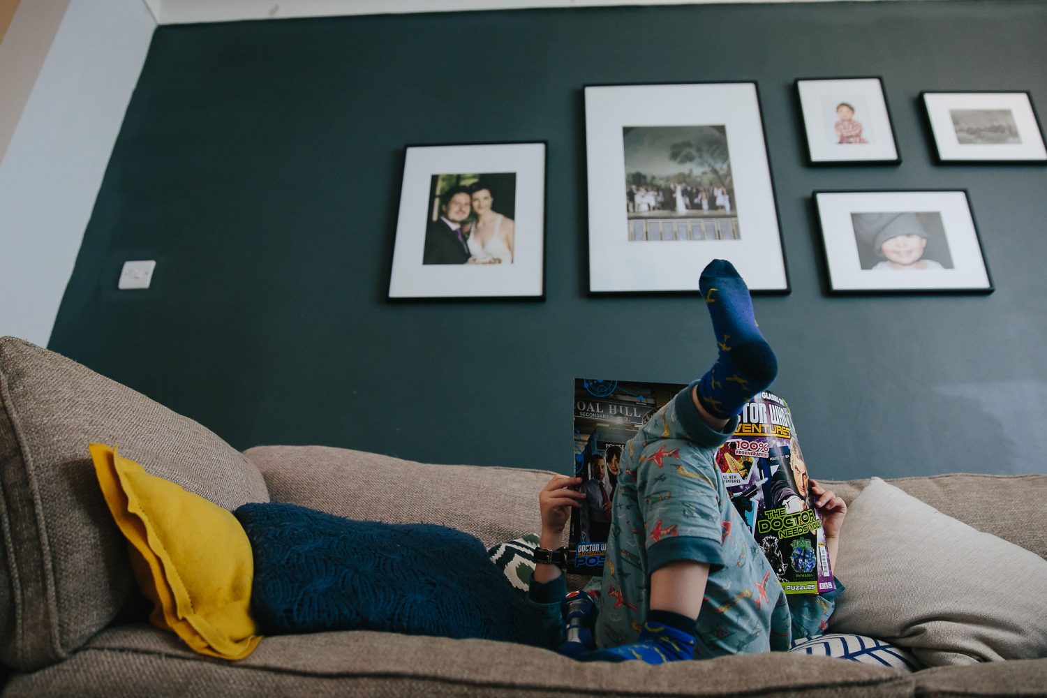 young boy reading on sofa day in the life photography
