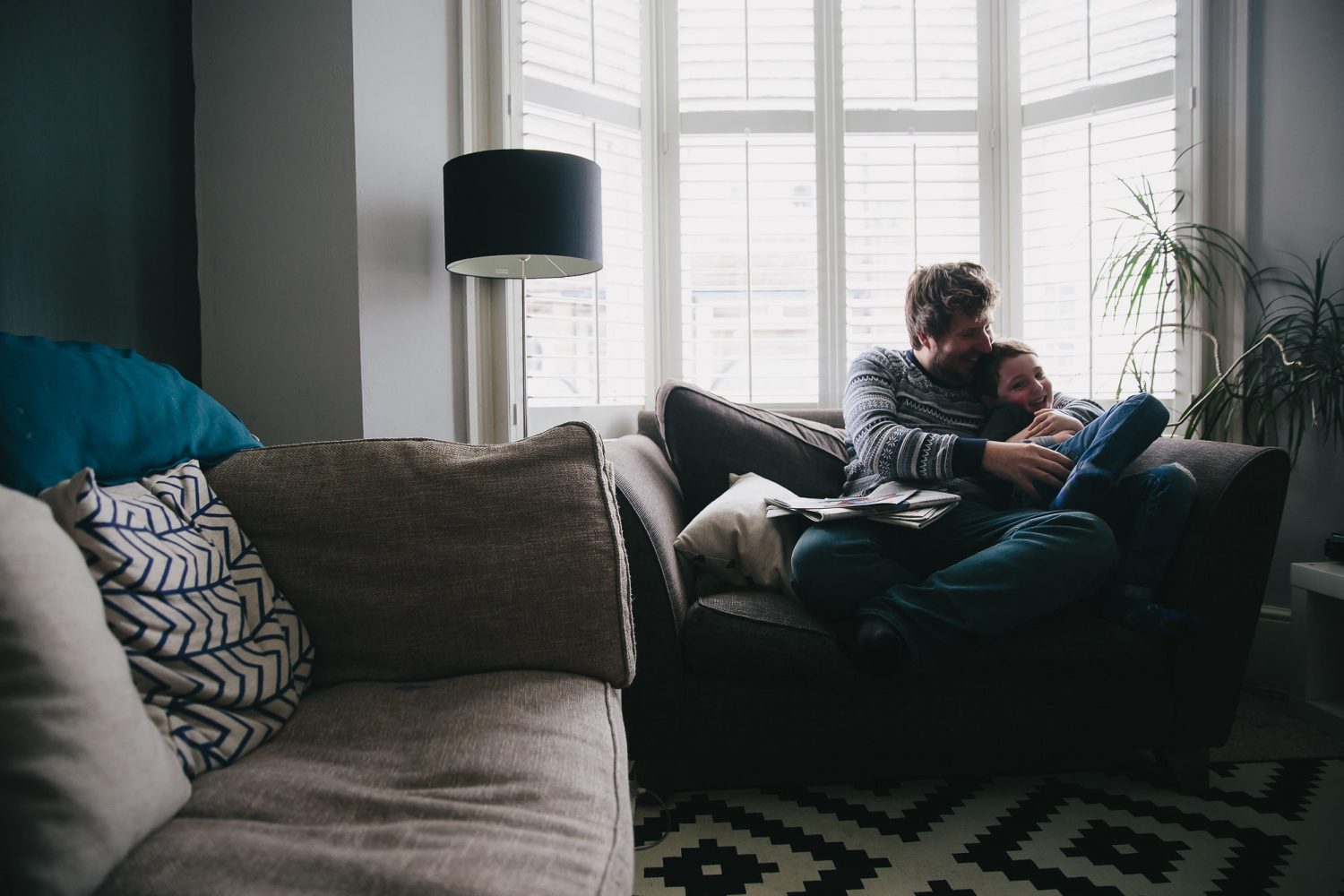 day in the life photography dad with child on sofa relaxing