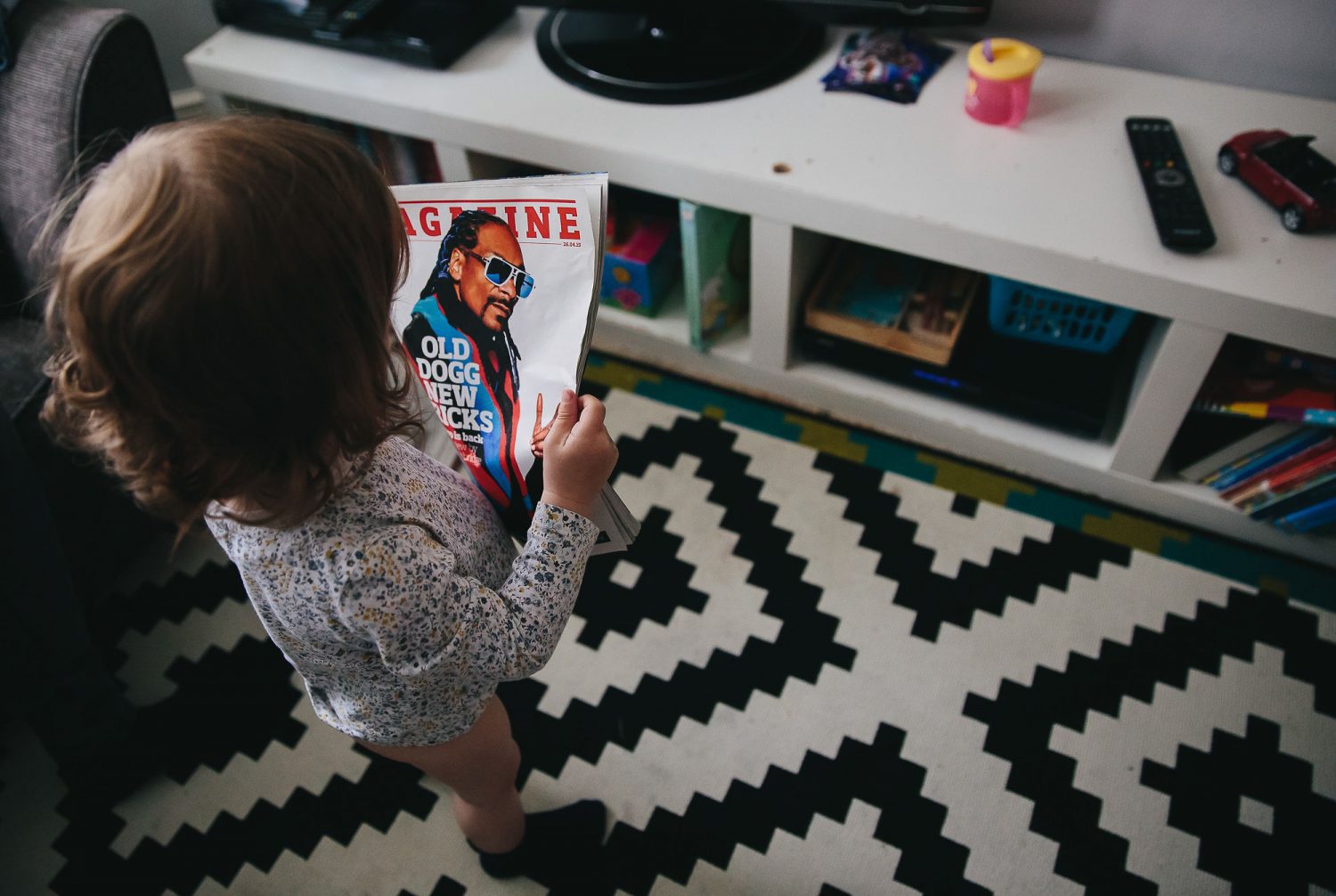 child reading a magazine with snoop dogg on the cover