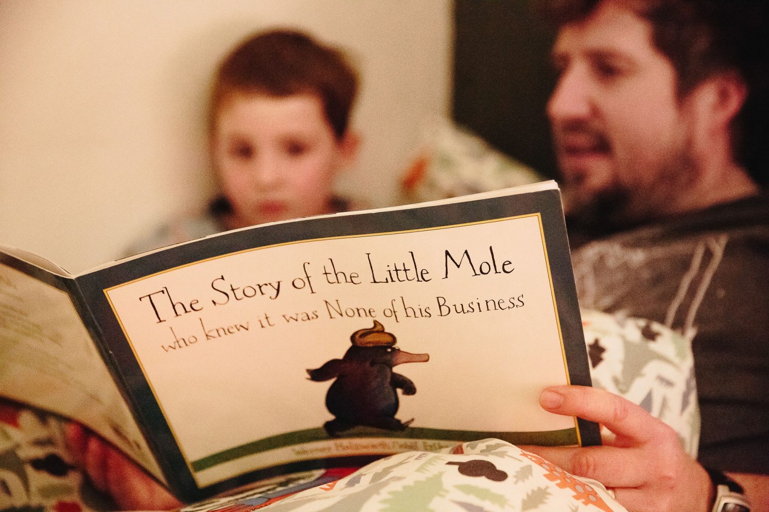 father reading his son a bedtime story day in the life photography