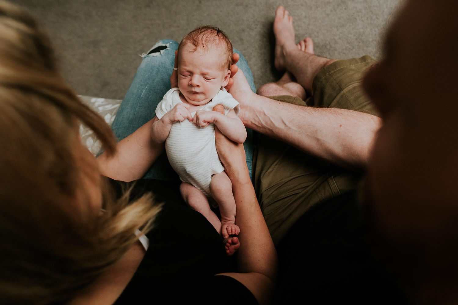 newborn photo shoot at home parents looking down at baby