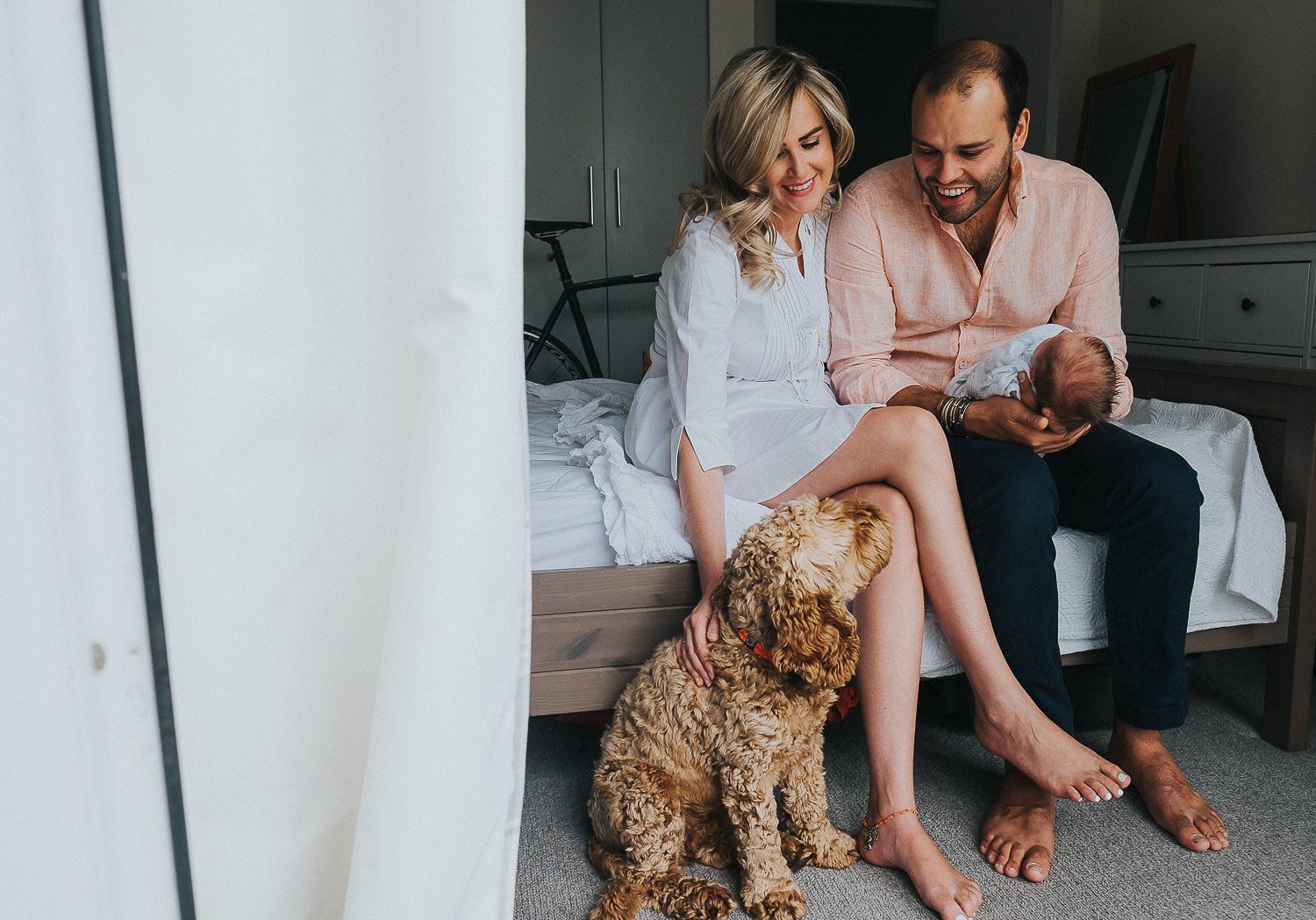 Newborn photo shoot at home, new parents with dog and baby