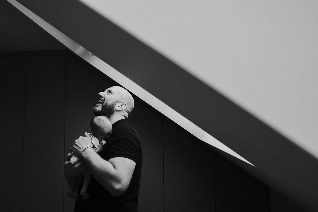 Survival tips from new parents - dad with newborn at window