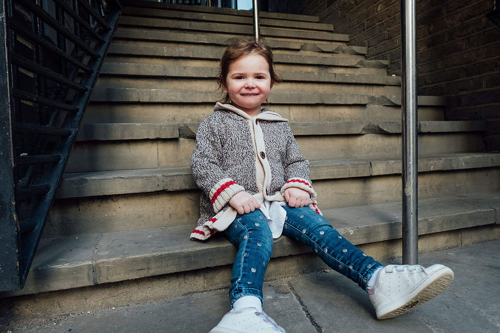 toddler girl sitting on steps in London