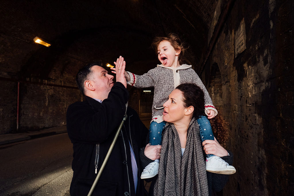 London family photographs parents with toddler in tunnel