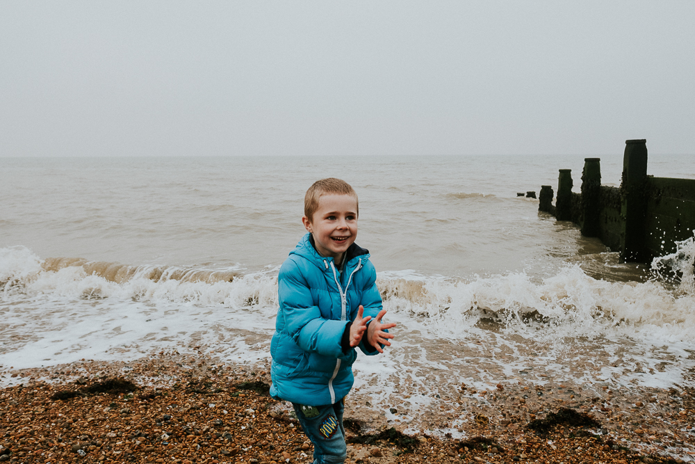Boy playing on beach at Tankerton Whitstable. Kent Christmas Mini Photo Shoots