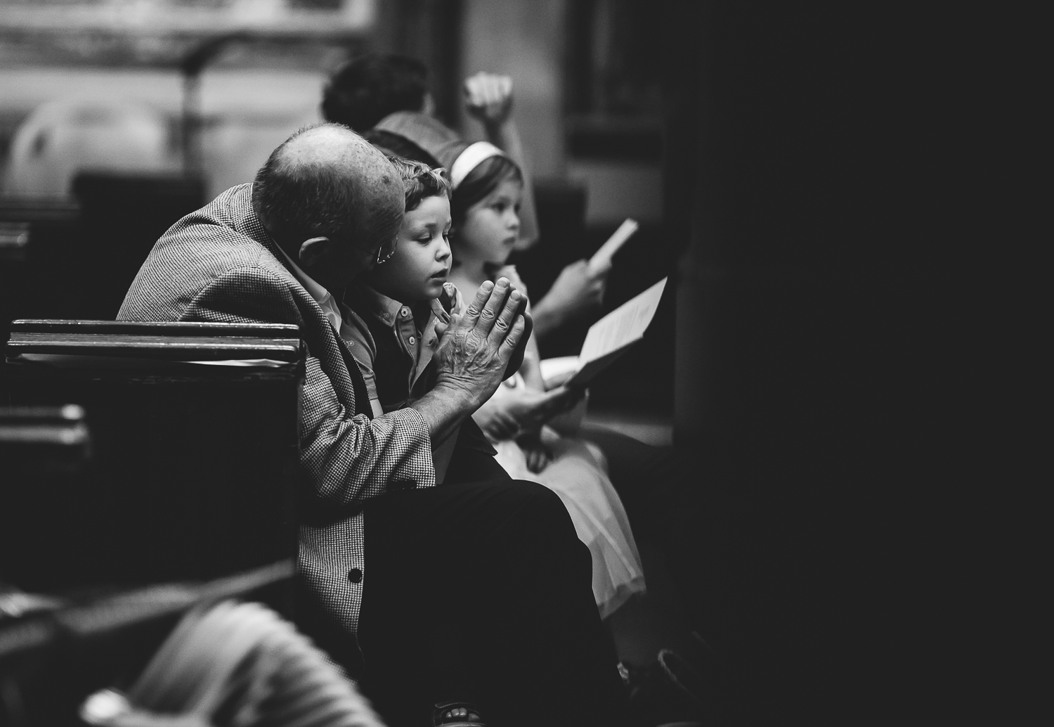 black and white small boy praying in church london christening photography