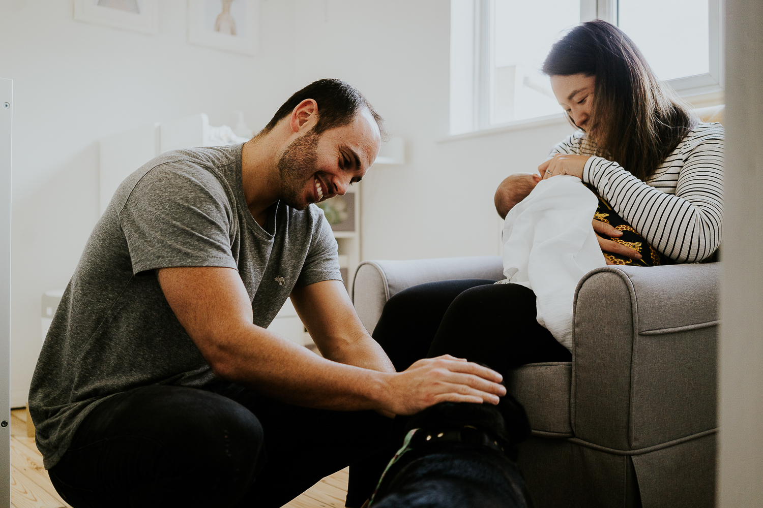 dad stroking dog whilst mum breastfeeds baby