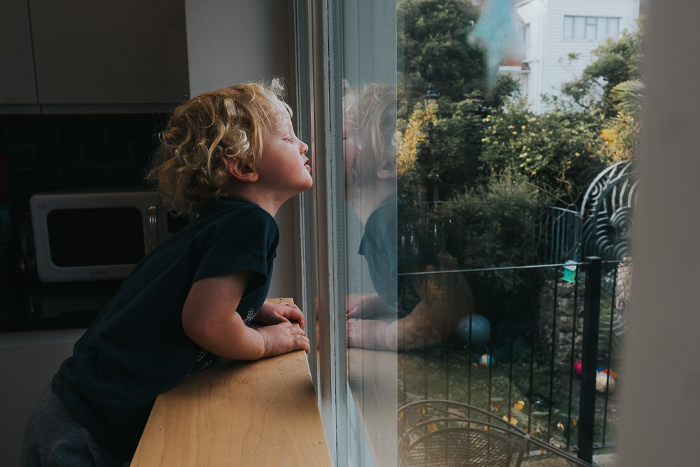 KIDS CORONAVIRUS LOCKDOWN CHILD LOOKING OUT OF WINDOW