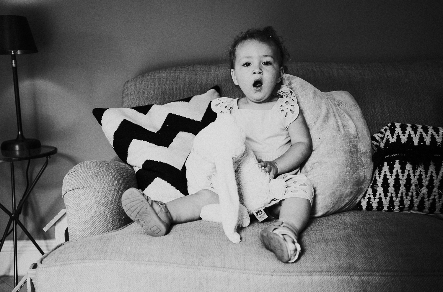 sibling family photography 2020 black and white portrait young girl on sofa yawning