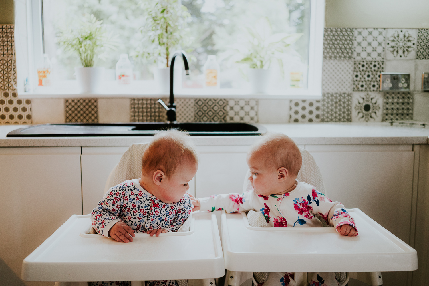 day in the life photo shoot twin baby girls in matching highchairs in kitchen