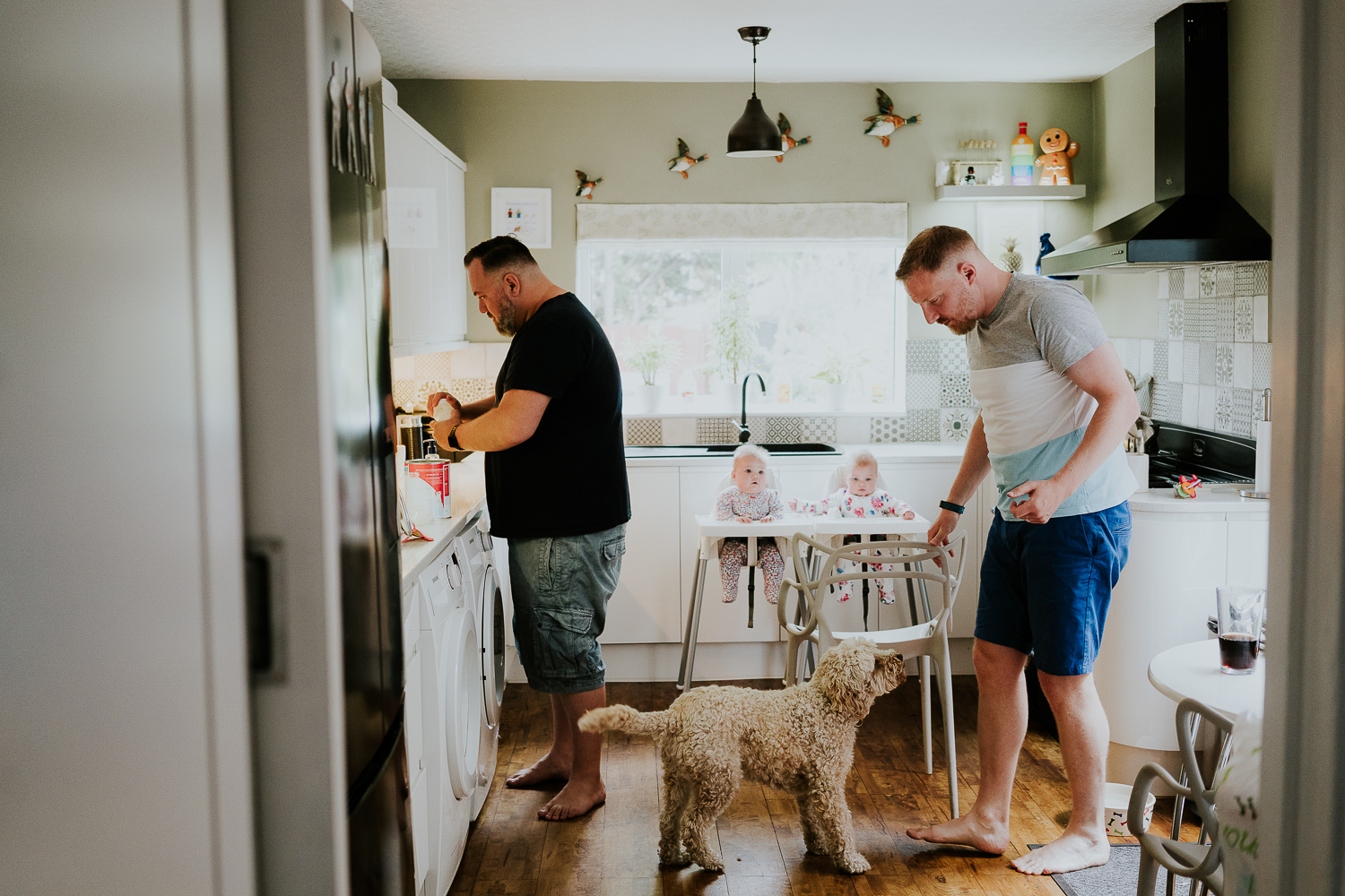 day in the life photo shoot two dads with baby twin girls in kitchen family scene