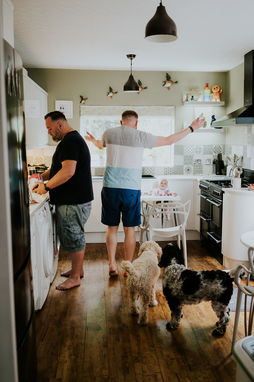 day in the life photo shoot two dads with baby twin girls in kitchen family scene