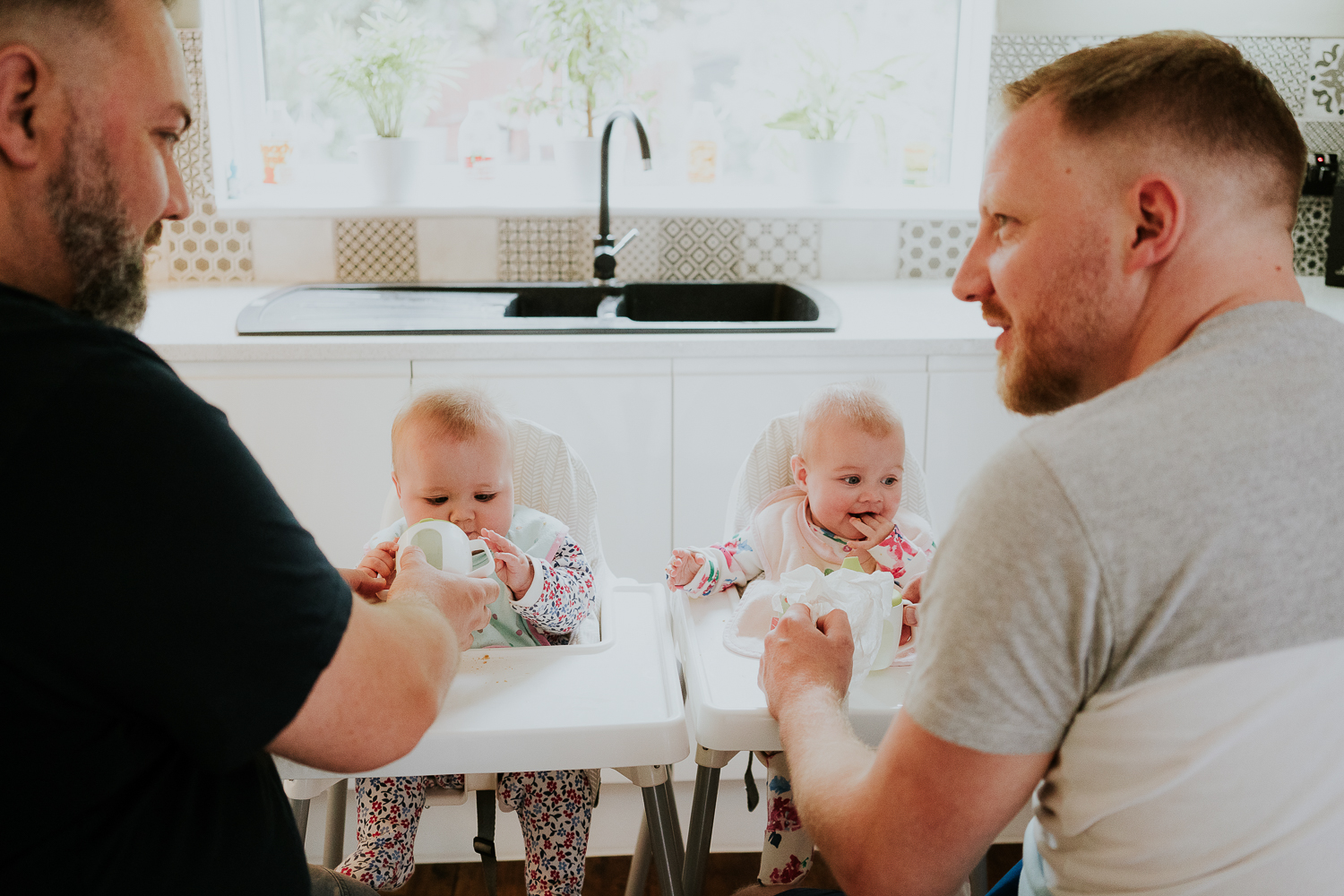 day in the life photo shoot two dads with baby twin girls in kitchen family scene