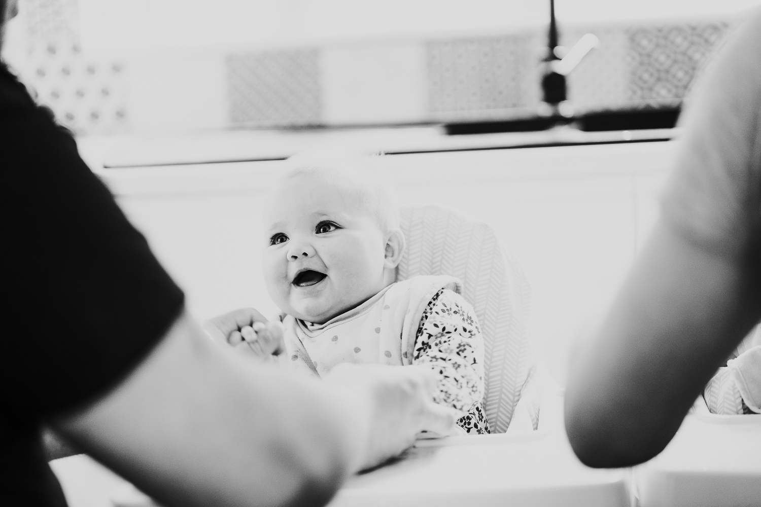 day in the life photo shoot baby girl smiling in highchair black and white