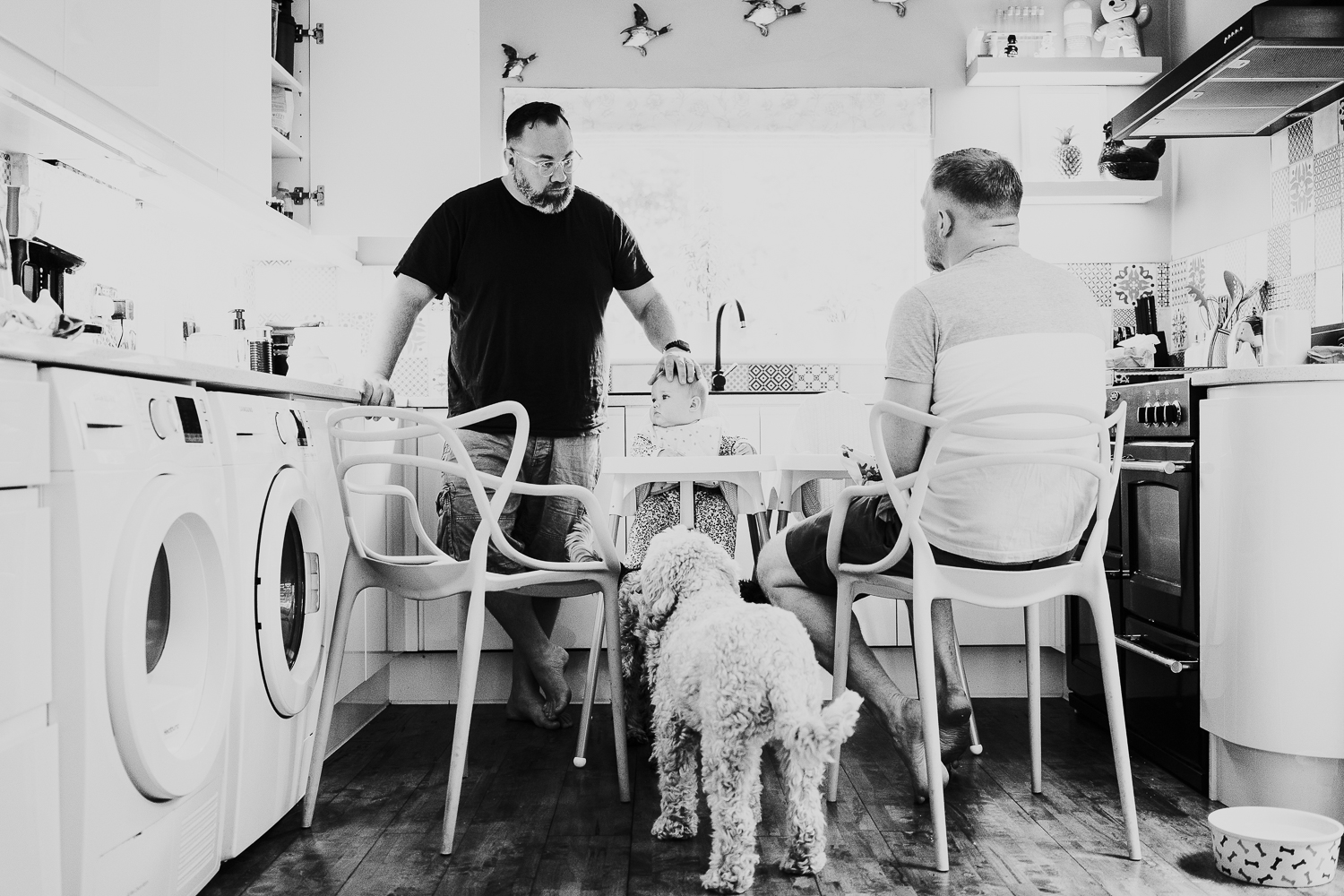 day in the life photo shoot two dads with baby twin girls in kitchen family scene