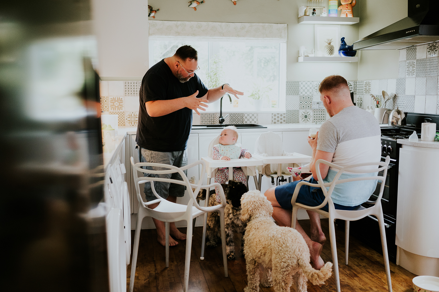 day in the life photo shoot two dads with baby twin girls in kitchen family scene