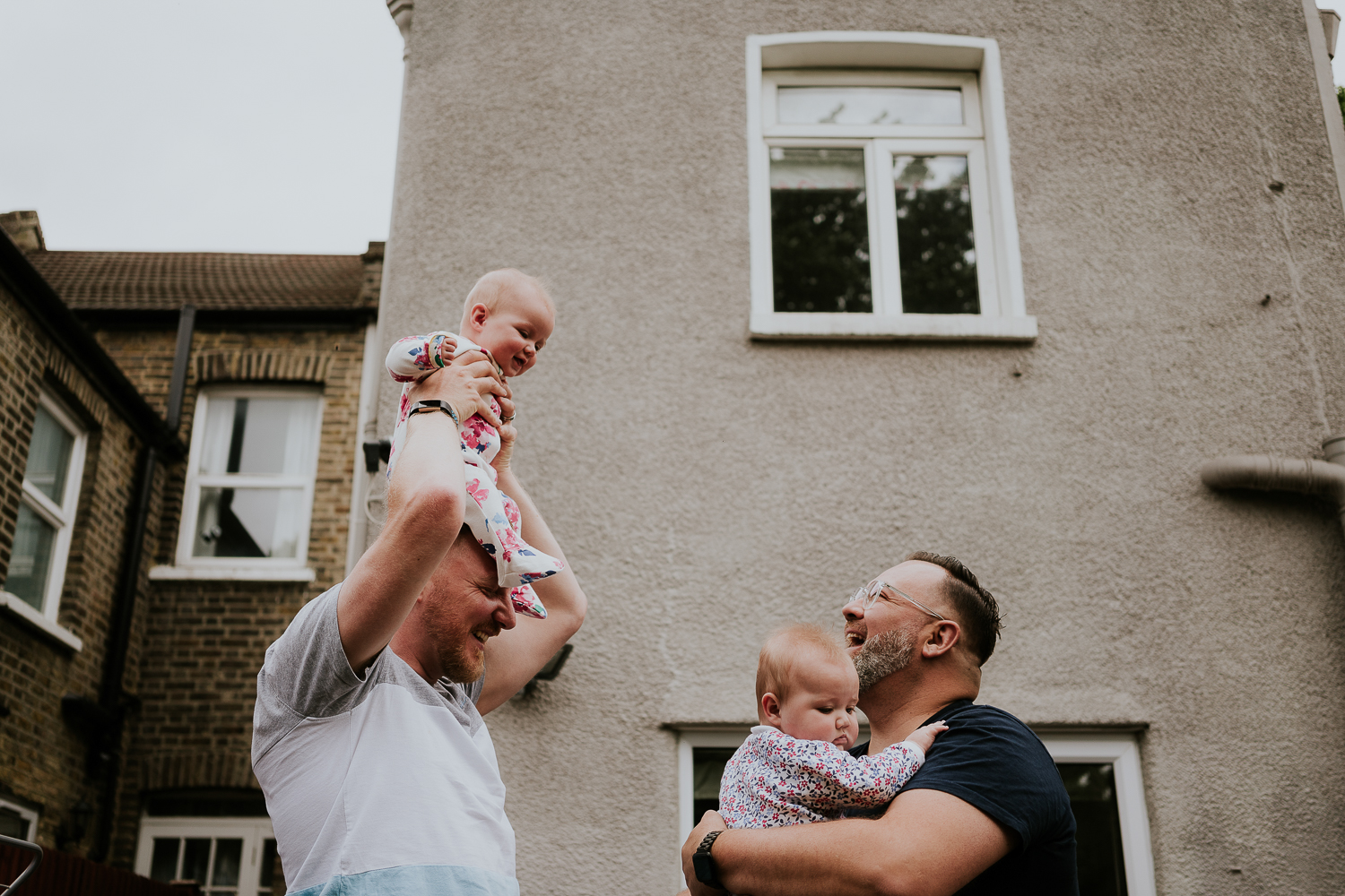 day in the life photo shoot two dads and twin baby daughters playing outside family home