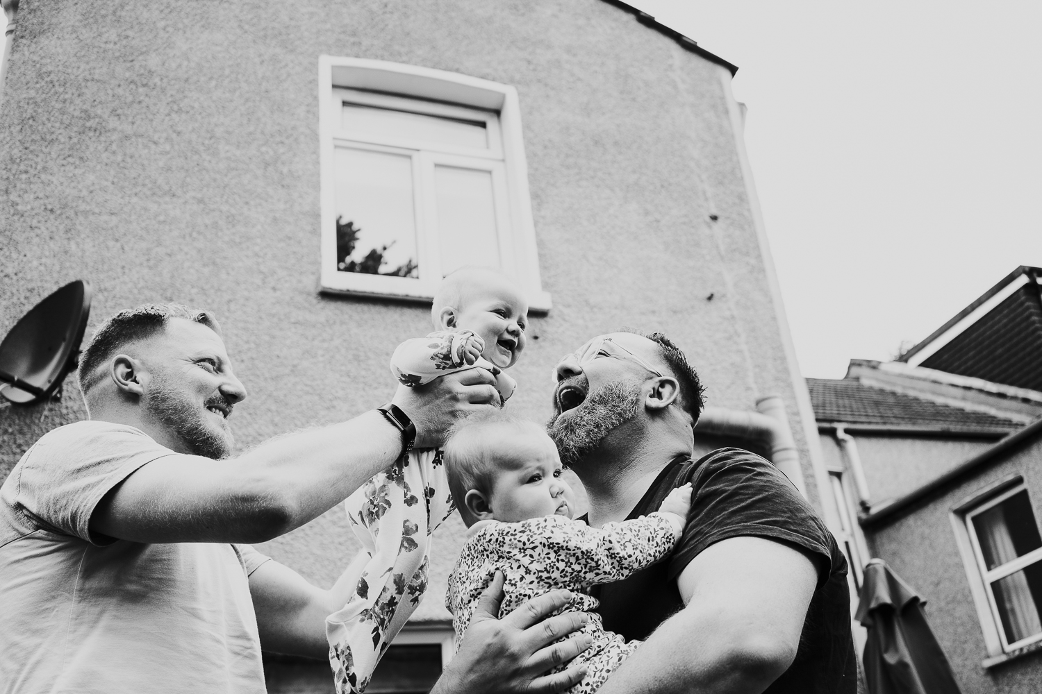 day in the life photo shoot two dads and twin baby daughters playing outside family home