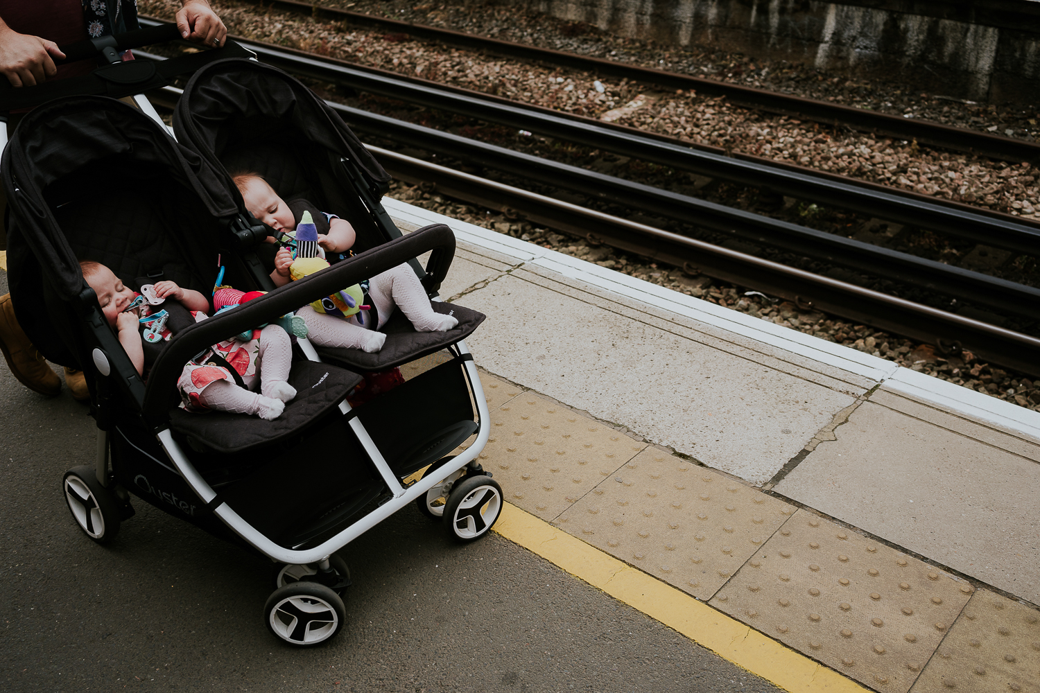 day in the life photo shoot twin baby girls in double pushchair on train platform
