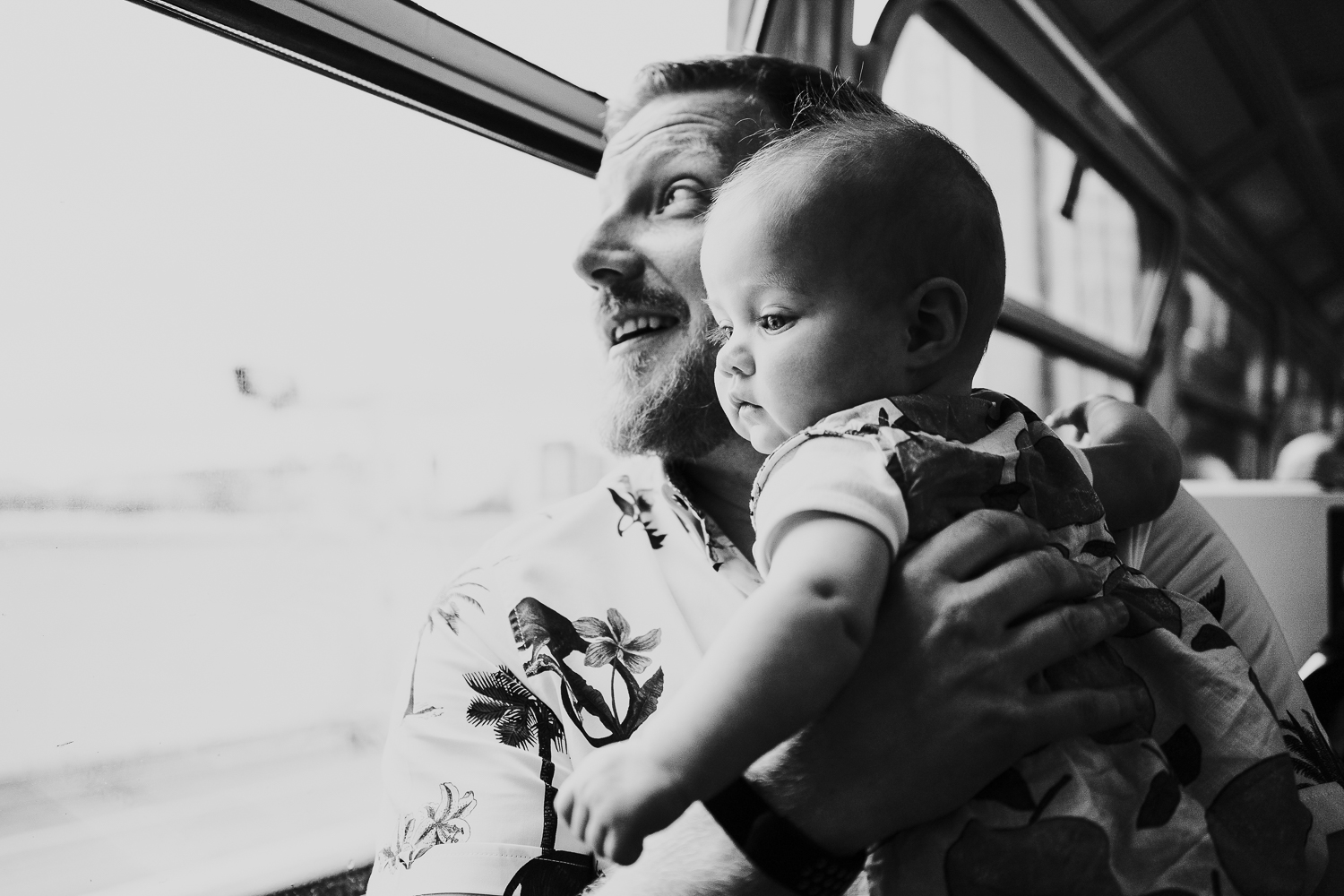 day in the life photo shoot father and baby girl on train black and white shot looking out of window