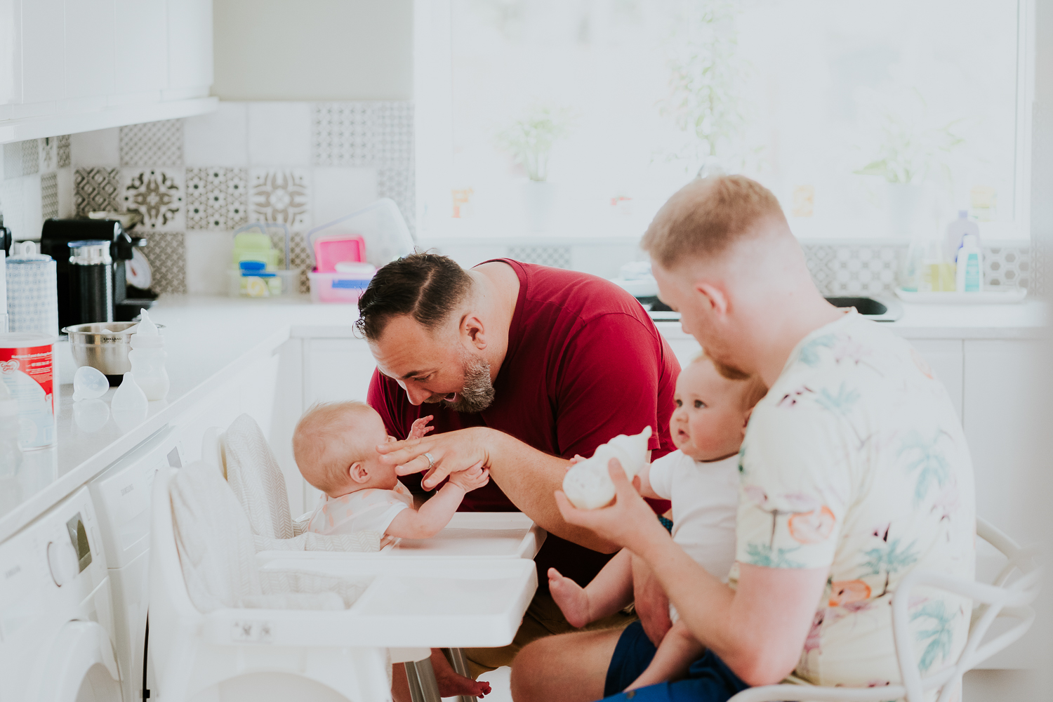 day in the life photo shoot two dads with baby twin girls in kitchen family scene