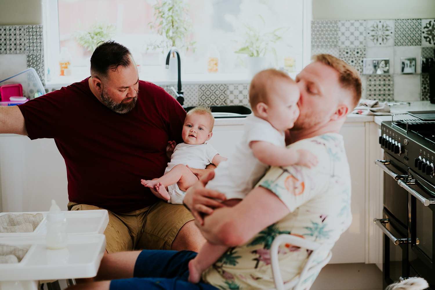 day in the life photo shoot two dads with baby twin girls in kitchen family scene