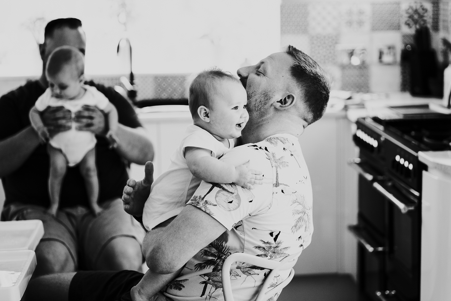 day in the life photo shoot two dads with baby twin girls in kitchen family scene