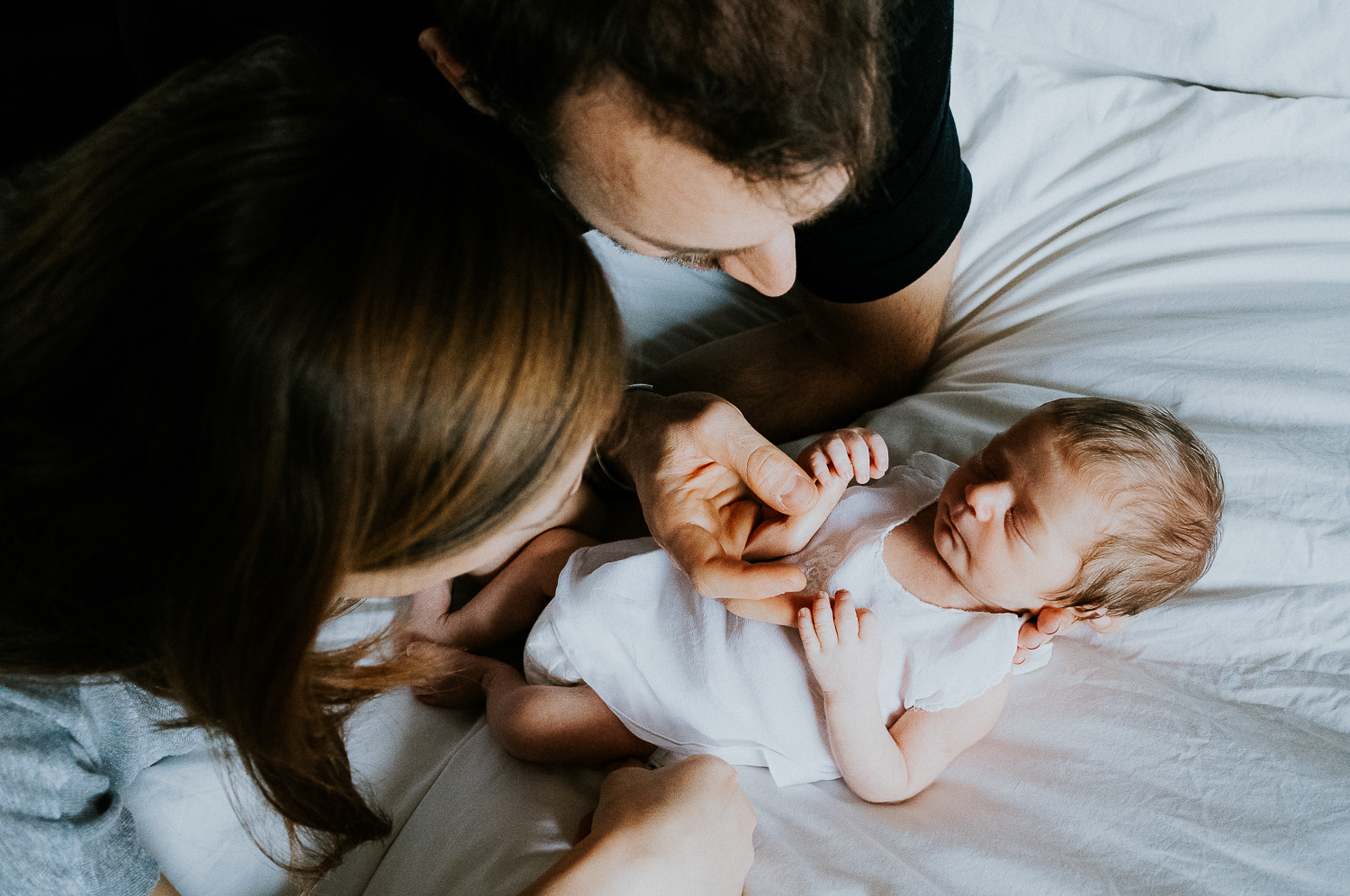 east london newborn photographer mother, father and baby on bed
