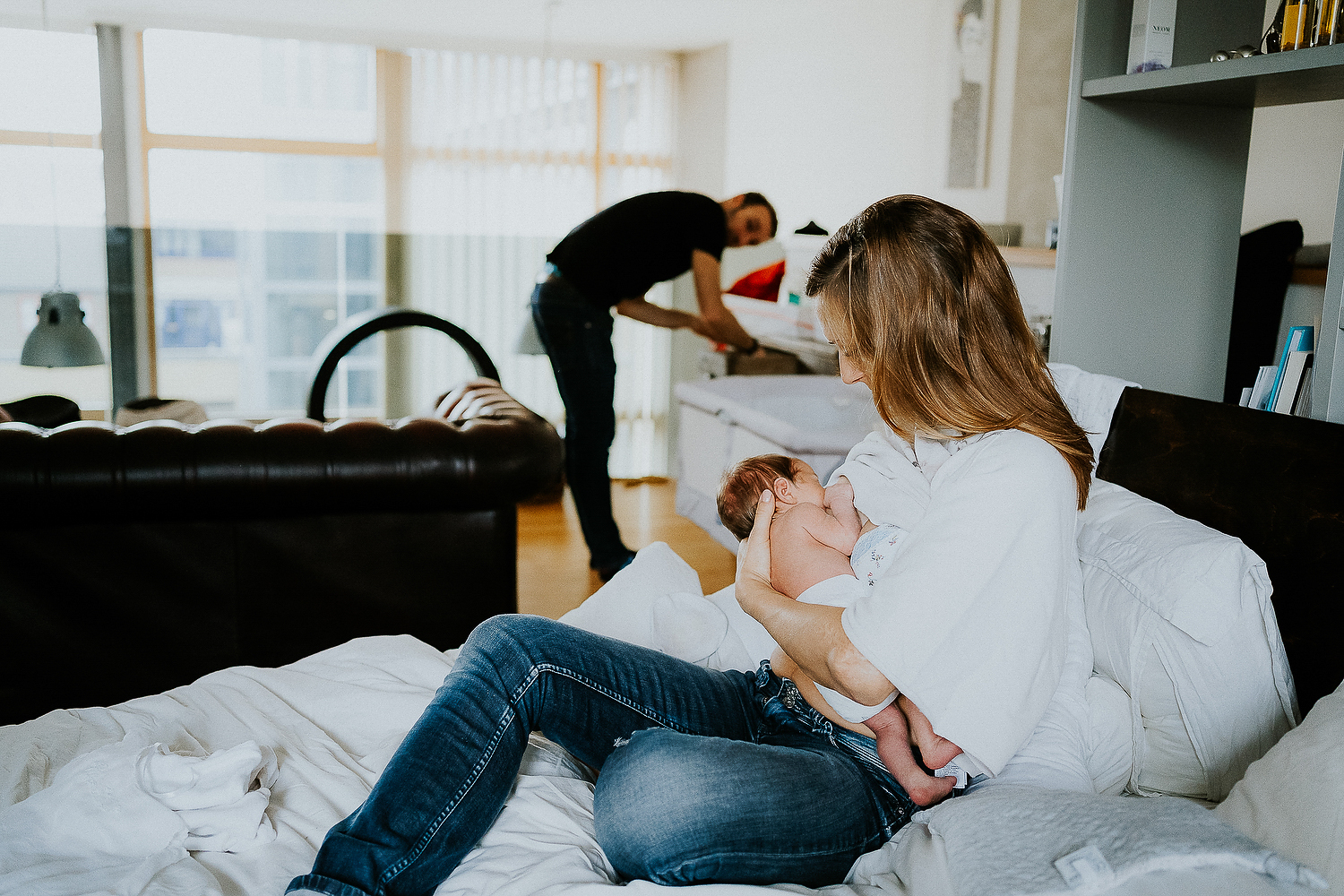 east london newborn photographer mother breastfeeding baby on bed