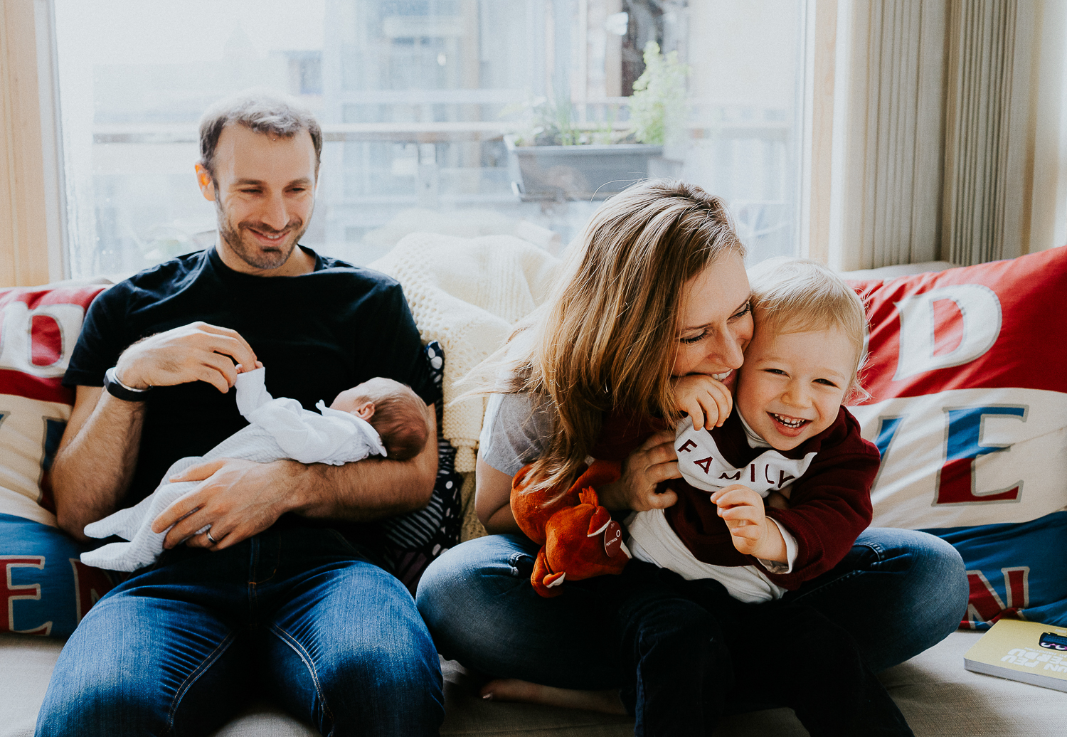 east london newborn photographer mother, father, little boy and newborn baby on sofa