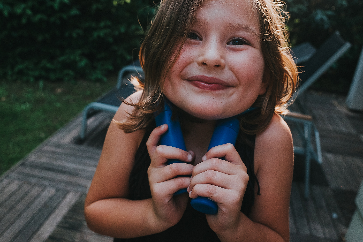 CLOSE UP CHEEKY SMILING GIRL PLAYING IN GARDEN FAMILY PHOTOGRAPHY AT CENTER PARCS FRANCE LAC D'AILETTE