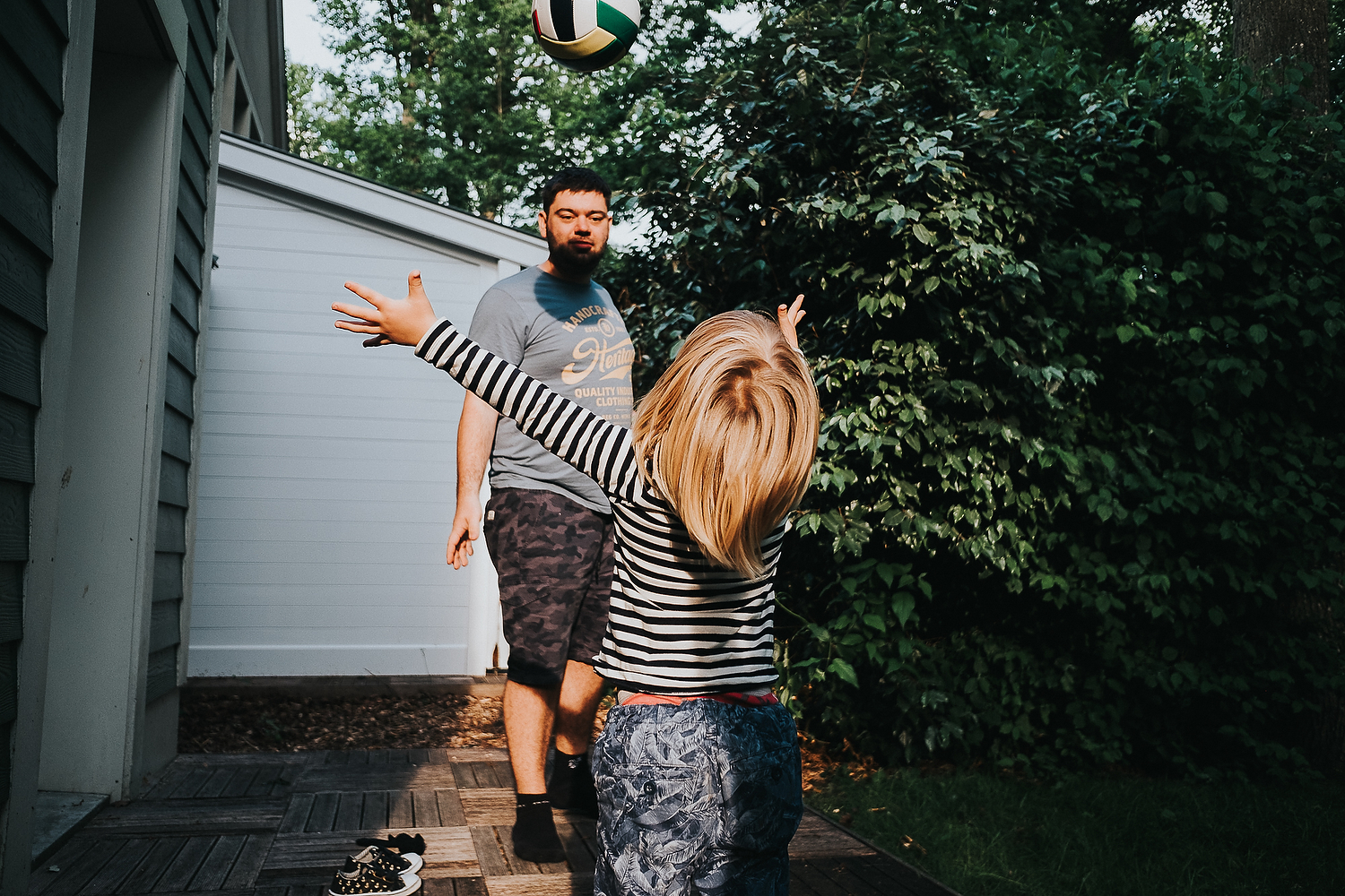 BOY AND FATHER PLAYING WITH FOOTBALL IN GARDEN FAMILY PHOTOGRAPHY AT CENTER PARCS FRANCE LAC D'AILETTE