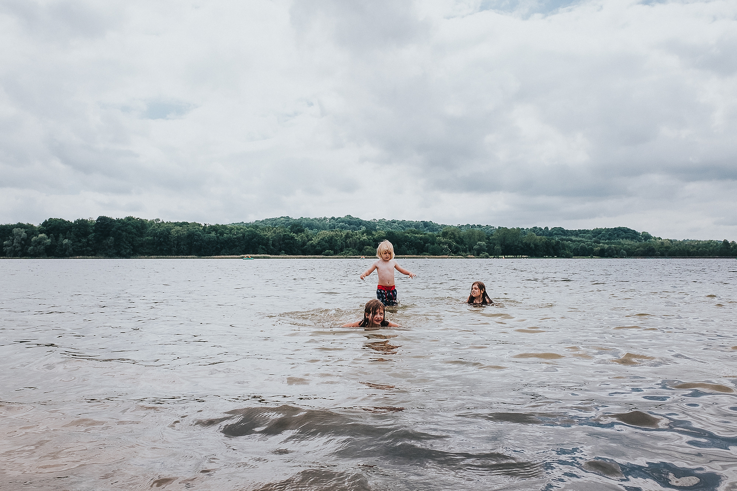 CHILDREN PLAYING AND SWIMMING TOGETHER IN LAKE FAMILY PHOTOGRAPHY AT CENTER PARCS FRANCE LAC D'AILETTE