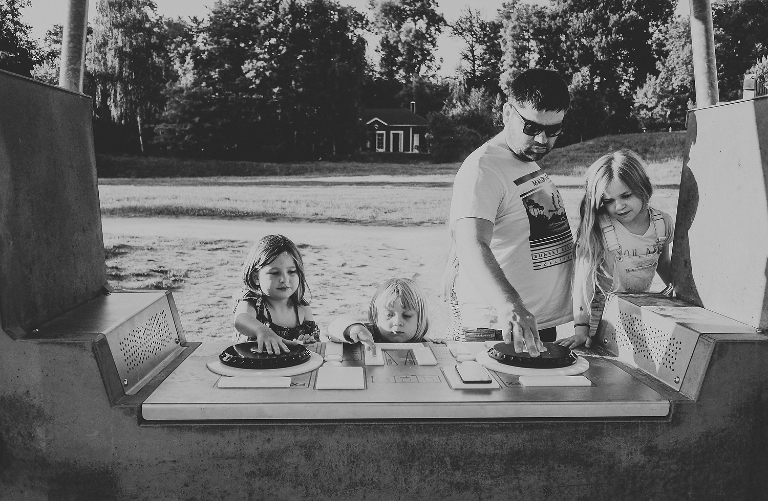 CHILDREN AND DAD PLAYING WITH DJ EQUIPMENT OUTDOORS FAMILY PHOTOGRAPHY AT CENTER PARCS FRANCE LAC D'AILETTE