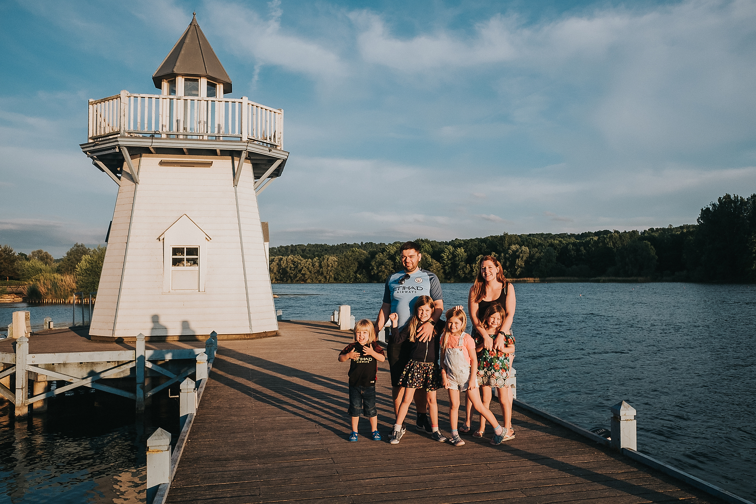 CHILDREN PLAYING BY LAKE ON BOARDWALK FAMILY PHOTOGRAPHY AT CENTER PARCS FRANCE LAC D'AILETTE